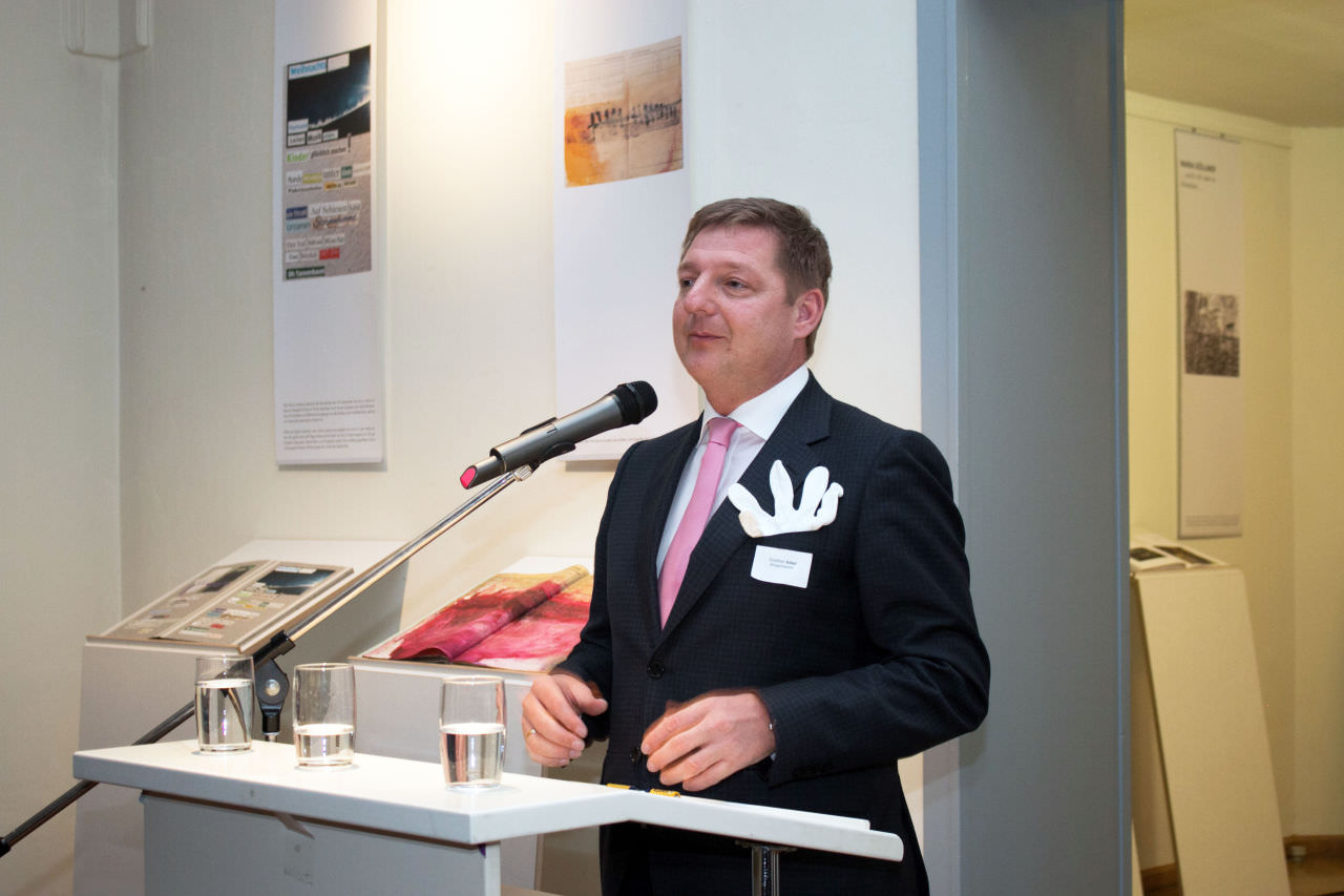 Bürgermeister Günther Albel bei der Eröffnung der Ausstellung in der Villa Dessauer in Bamberg. Der Baumwollhandschau – statt eines Stecktuches – symbolisiert, wie die Gäste in den Künstlerbüchern blättern können.