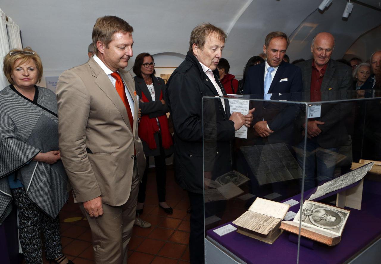 Museumsleiter Dr. Kurt Karpf präsentiert Bürgermeister Günther Albel und den Eröffnungsgästen historische Bibeln aus der Zeit Luthers.