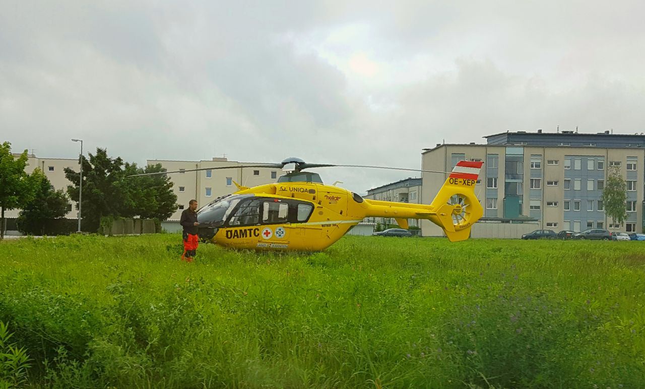 Ein ÖAMTC-Helikopter landet auf einer Wiese in Klagenfurt.