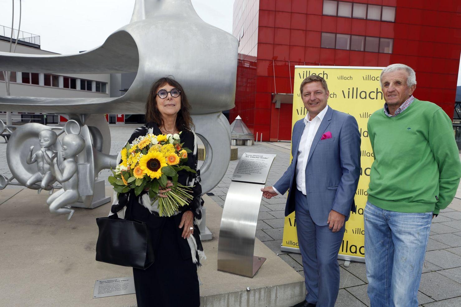 Gironcoli-Witwe Christine Gironcoli, Bürgermeister Günther Albel und Kunstmäzen Wolfgang Gabriel vor jener Skulptur, die dem Förderpreis für junge Künstlerinnen und Künstler den Namen gibt: „Wir Villacher Kinder“