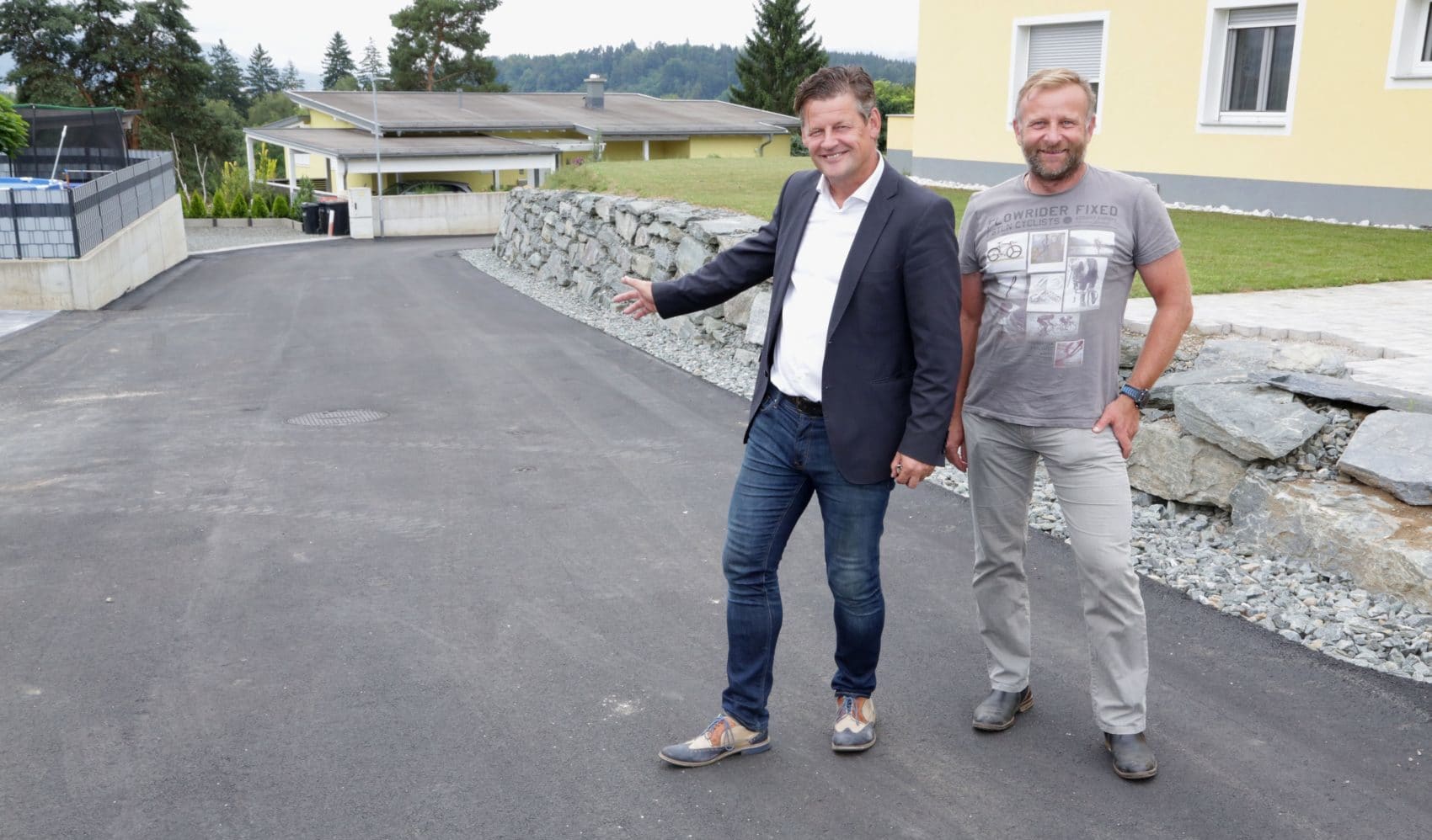 Straßenbaureferent Stadtrat Christian Scheider (links) und Ing. Jürgen Mitteregger besichtigen die sanierte Fahrbahn im Anton-Fuchs-Weg.