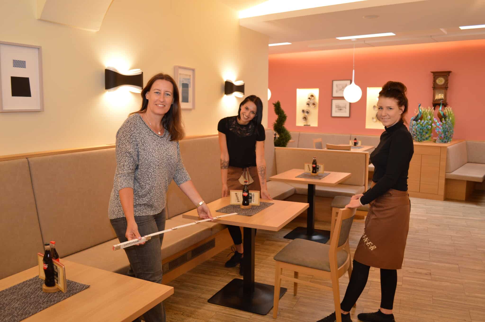 Café-Konditorei Rainer-Chefin Katharina Rainer-Valtiner mit ihren Mitarbeiterinnen beim Ausmessen der Tisch-Abstandsregeln. Am Freitag öffnen rund 100 Gastro-Betriebe in der Villacher Innenstadt.