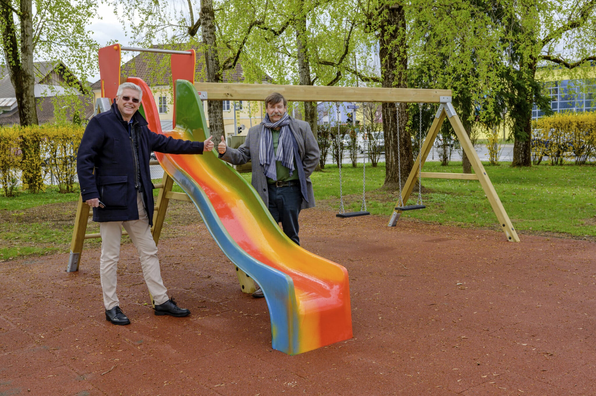 Vizebürgermeister Alois Dolinar und Reinfried Oblasser, Geschäftsführer von Klagenfurt Wohnen, besichtigen die neuen Spielgeräte.